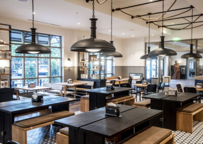 The Cotton House indoor view of industrial style chandeliers and tables, with lighting created by Robinson Electric