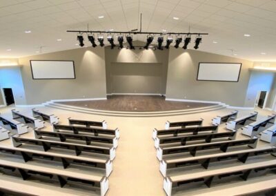 An auditorium is well lit with spotlights and ambient light