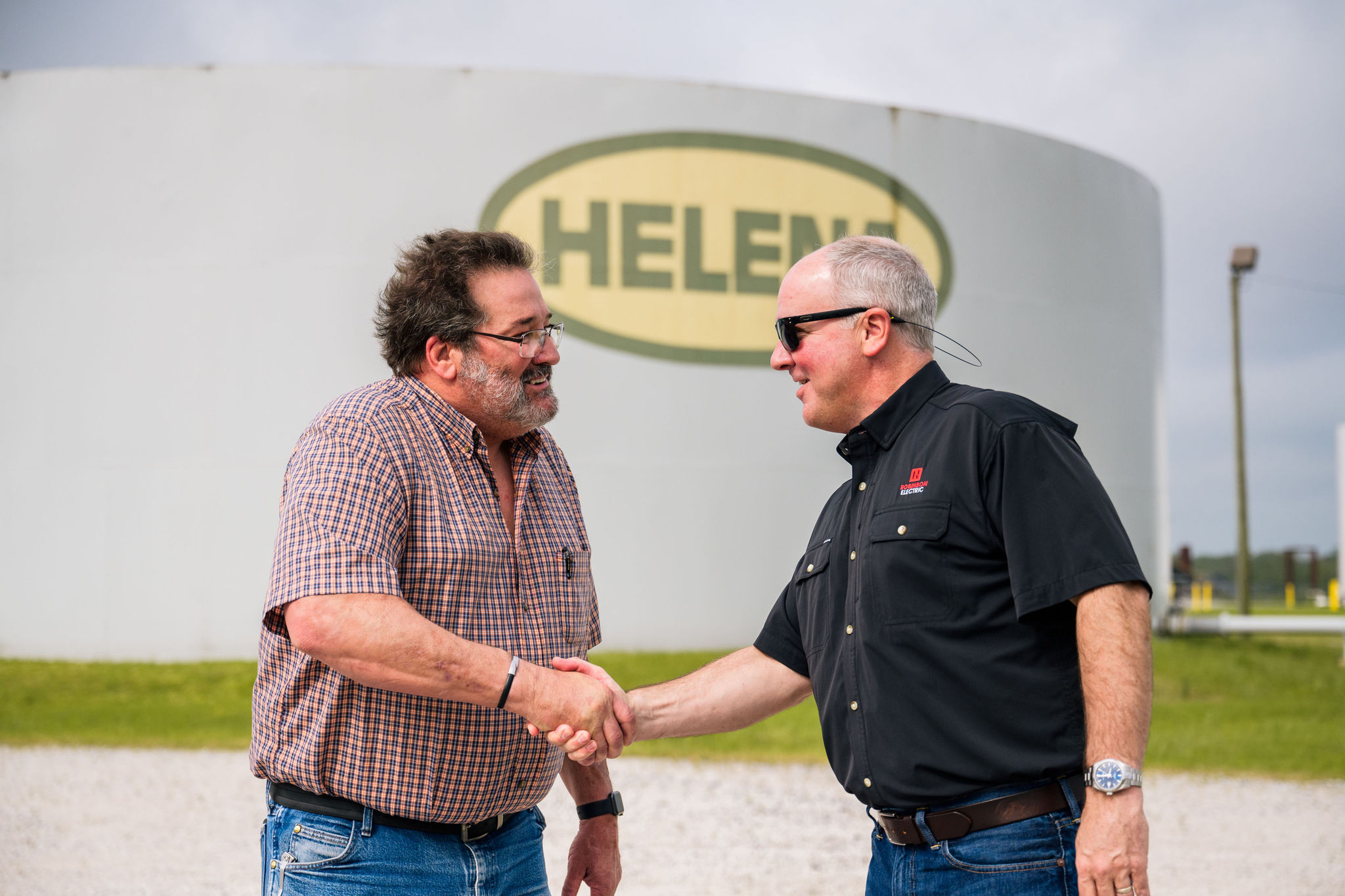 a white truck with the Robinson Electric logo on its side drives to a job site