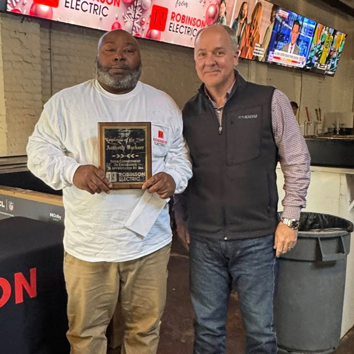 Anthony Buckner holds his "Employee of the Year" plaque while posing with Brian Robinson. 