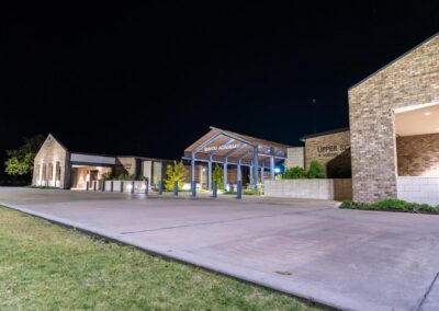 A side angle view of the entrance to Bayou Academy. The sign shines brightly in the night sky.